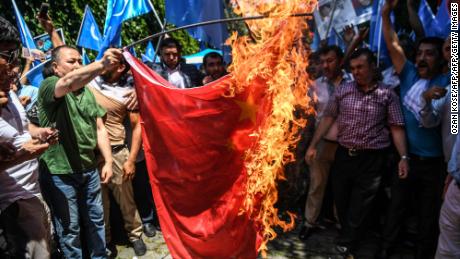 Protesters burn a Chinese flag during a demonstration to denounce China&#39;s treatment of Uyghurs in front of the Chinese consulate in Istanbul, on July 5, 2018.