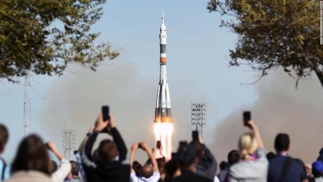 A crowd watches as the Soyuz-FG rocket booster lifts off from the Baikonur Cosmodrome. Dramatic footage minutes later showed the capsule carrying the crew as it parachuted back to Earth before thumping down in a plume of dust in Kazakhstan, about 250 miles away from where it took off.&lt;br /&gt;