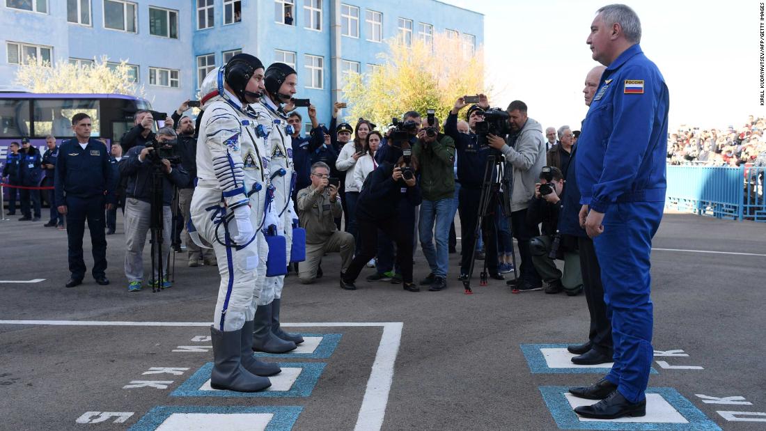 Nick Hague and Alexey Ovchinin report to Roscosmos head Dmitry Rogozin before boarding the Soyuz MS-10 spacecraft.