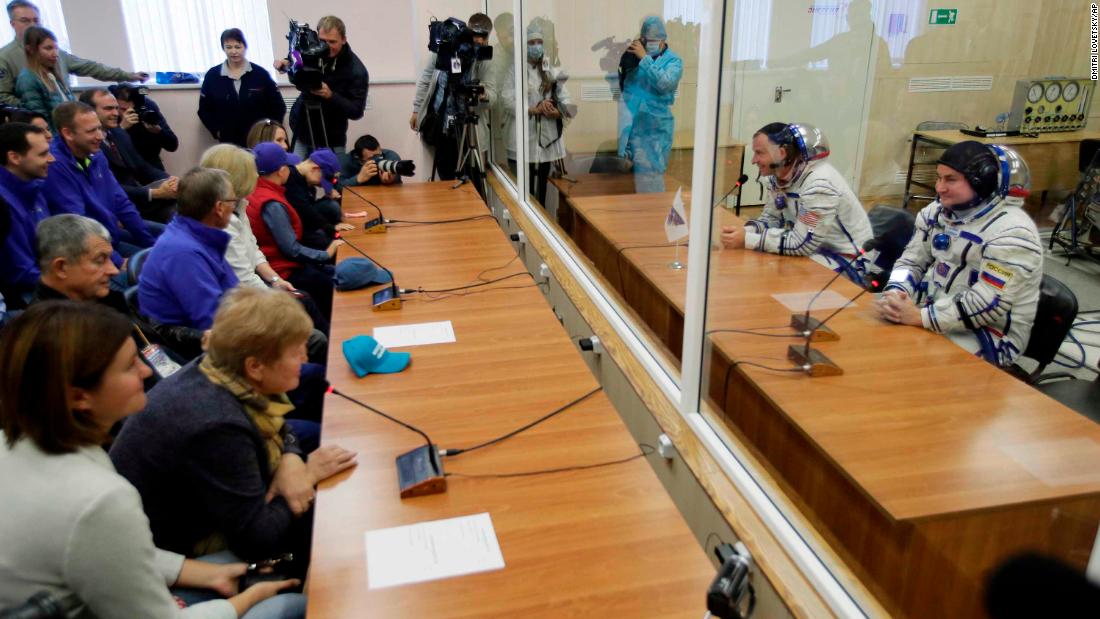 Hague and Ovchinin speak with their relatives through safety glass prior to the launch of Soyuz MS-10.