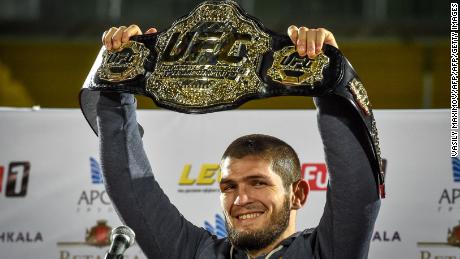 UFC lightweight champion Khabib Nurmagomedov of Russia raises his champions belt upon the arrival in Makhachkala on October 8, 2018. - Nurmagomedov defeated Conor McGregor of Ireland in their UFC lightweight championship bout by way of submission during the UFC 229 event inside T-Mobile Arena on October 6, 2018 in Las Vegas, Nevada. (Photo by Vasily MAXIMOV / AFP)        (Photo credit should read VASILY MAXIMOV/AFP/Getty Images)