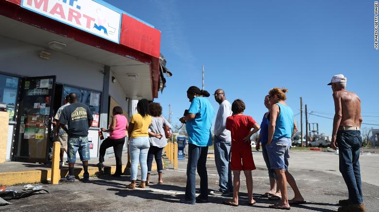 People line up Friday outside a Panama City convenience store in the aftermath of Hurricane Michael.