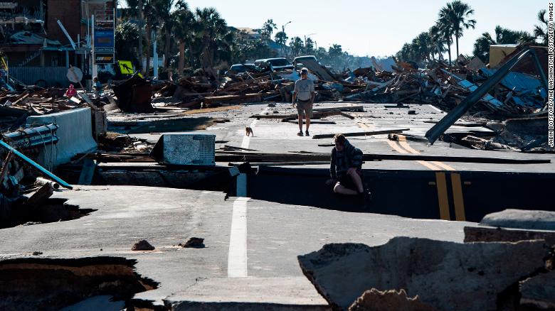 Residents make their way across a washed-out road on Friday, October 12, in Mexico Beach, Florida, a resort town that's been ground zero of the catastrophic hurricane's destruction.