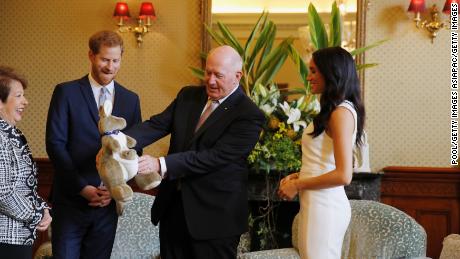 Prince Harry and Meghan Markle look at a plush kangaroo with Australia's Governor-General Peter Cosgrove and his wife, Lynne Cosgrove.