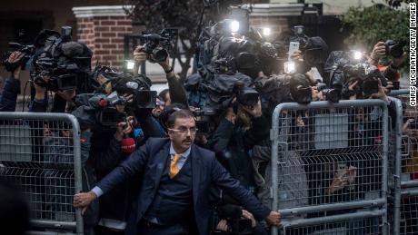 An unidentified man tries to hold back the press as  Saudi investigators arrive at the Saudi Arabian consulate ahead of Turkish police. 