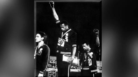 Tommie Smith (centru) și John Carlos (dreapta) pe podium la Olimpiada din Mexico City din 1968.