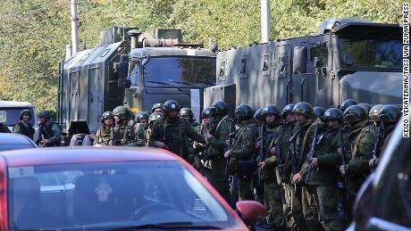 Law enforcement officers wait outside the college in the Crimean city of Kerch.