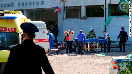 Medical workers treat injured people outside the college building in Kerch, Crimea.