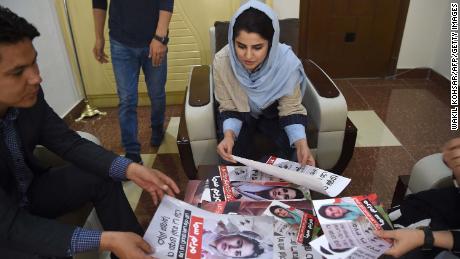 Afghan parliamentary election candidate Maryam Samaa, 26, checks her election campaign posters in Kabul on September 26.