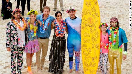 Britain's Prince Harry and Meghan, Duchess of Sussex pose for a photo with local surfing community group at Bondi Beach in Sydney, on October 19.