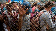 Honduran migrants wait outside the border between Guatemala and Mexico, in Tecun Uman, Guatemala, Friday, Oct. 19, 2018. Thousands of migrants traveling in a caravan briefly moved toward a border crossing on the Mexico-Guatemala frontier before turning around. Guatemala has closed its border gate and is standing guard with dozens of troops and two armored jeeps. 