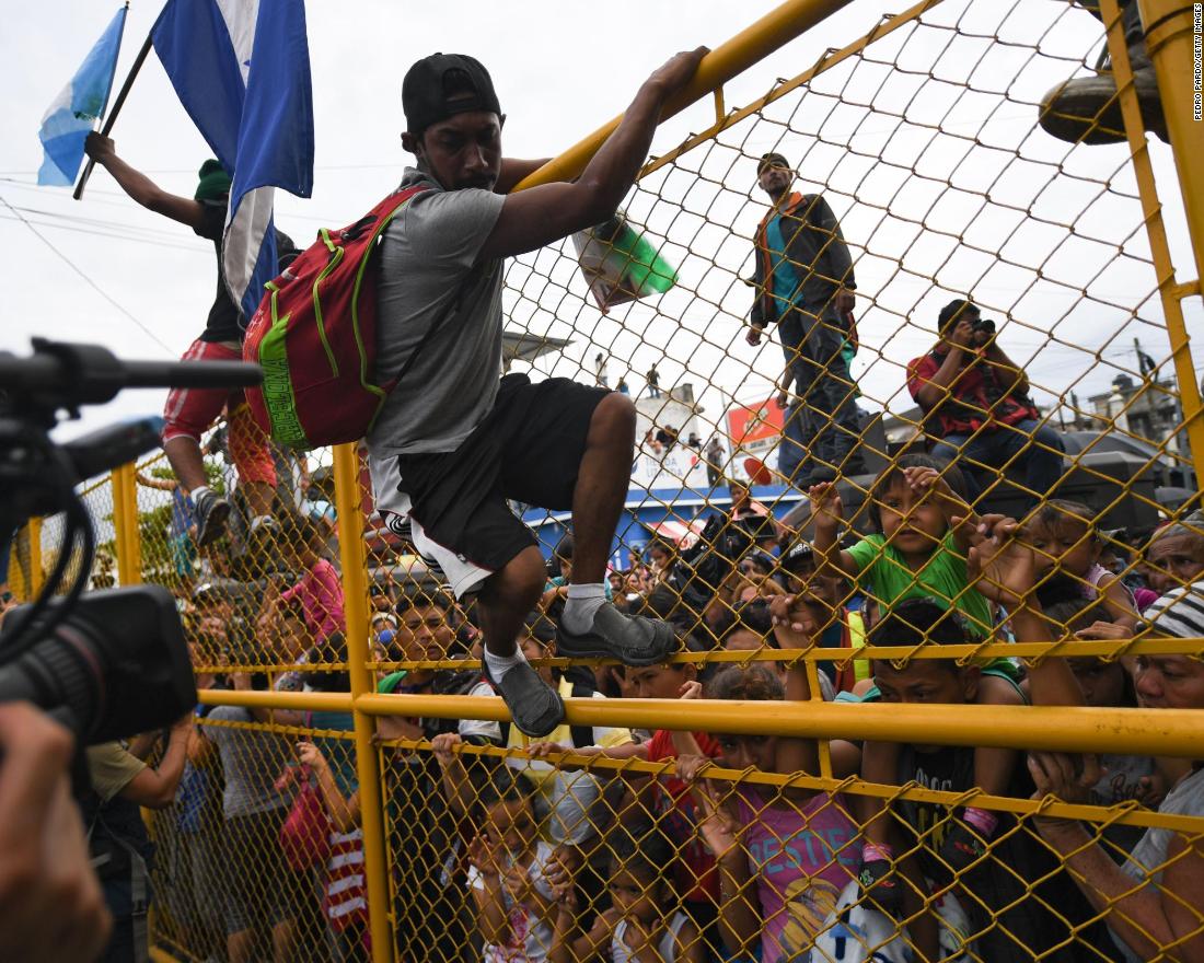 Honduran migrants heading in a caravan to the United States crowd the gate of the Guatemala-Mexico border bridge in Ciudad Hidalgo, Mexico, on Friday, October 19.