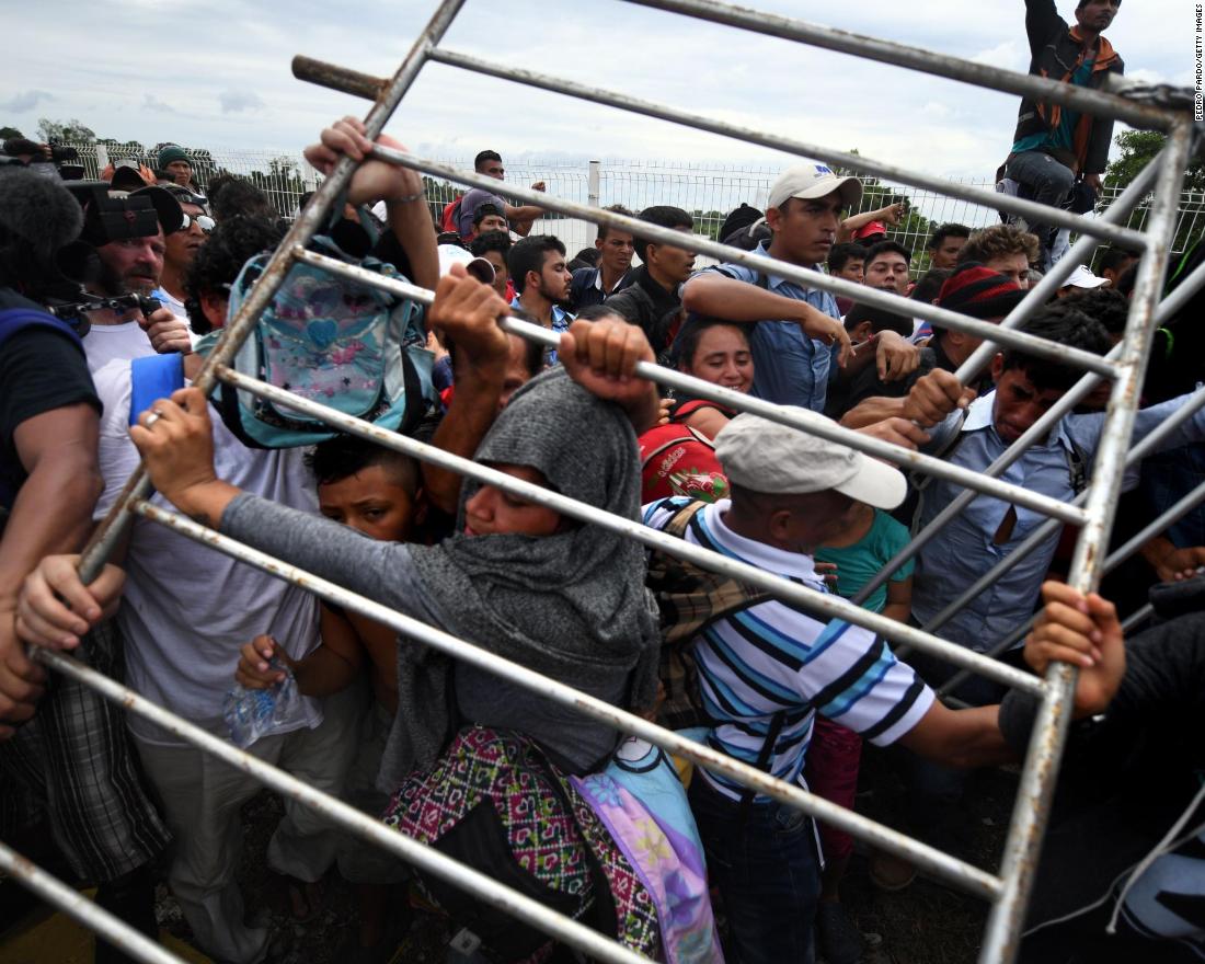 Honduran migrants heading in a caravan to the United States remove a barrier at the Guatemala-Mexico border bridge in Ciudad Hidalgo, Mexico, on Friday, October 19.