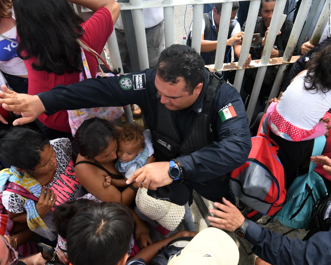 Mexican federal police officers allow women and children taking part in a caravan of Honduran migrants heading to the United States to cross to Mexico in the border city of Tecun Uman, Guatemala, on Friday, October 19. 