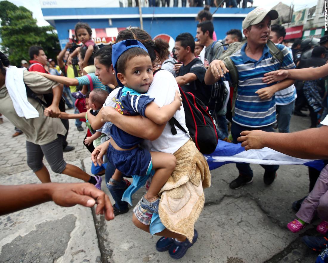 A Honduran migrant, part of a caravan trying to reach the United States, storms the checkpoint between Guatemala and Mexico in Tecun Uman, Guatemala, Friday, October 19.