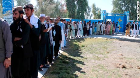 Afghan men line up to cast votes Saturday in Helmand province.