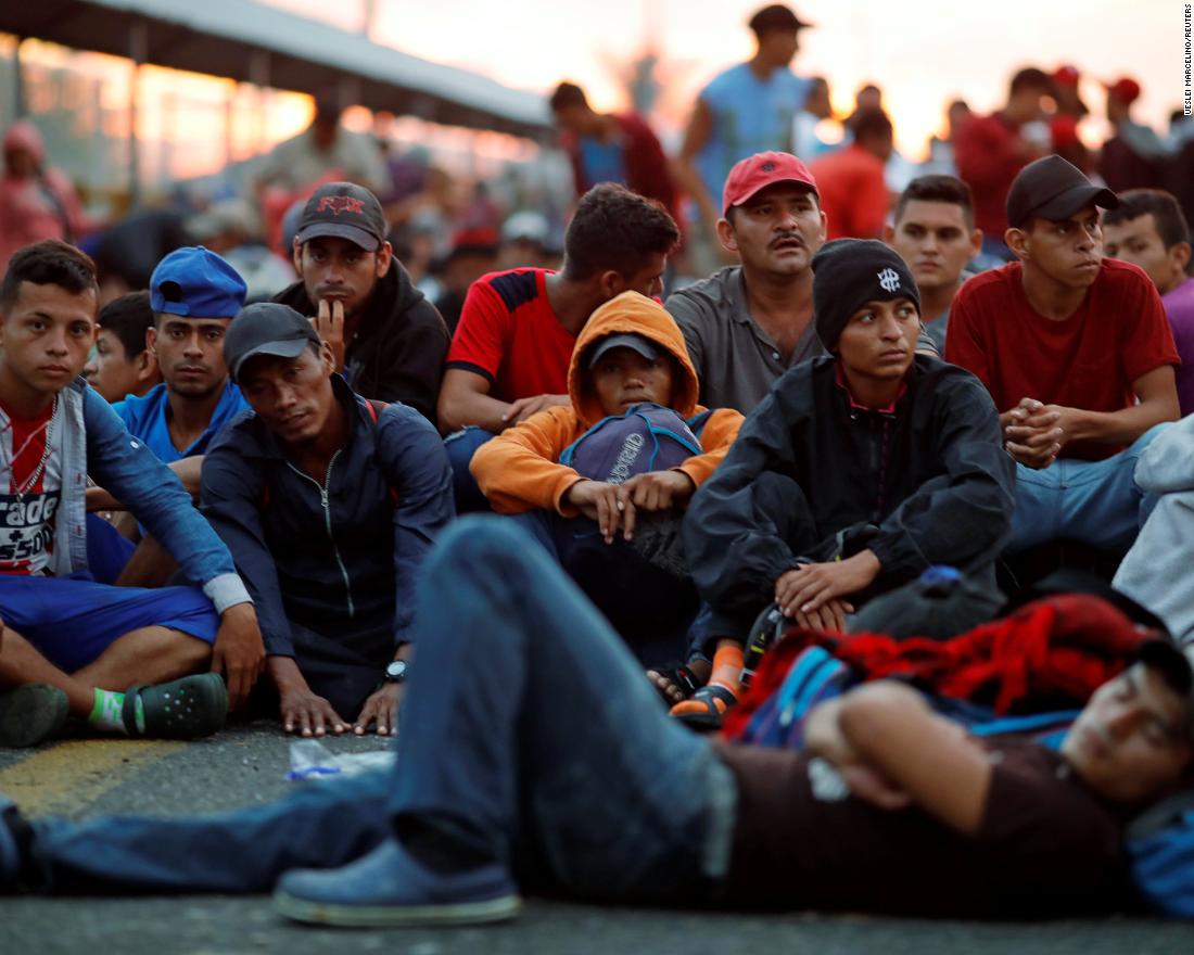 Migrants in the caravan wait on Saturday for the opening of the gate on the bridge that connects Guatemala to Mexico.