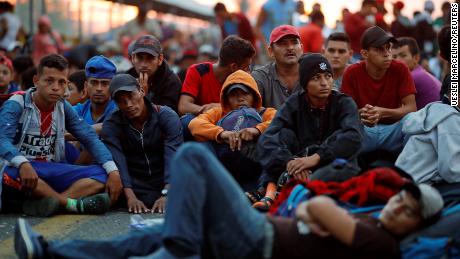 Honduran migrants wait for a gate on a bridge connecting Mexico and Guatemala in Ciudad Hidalgo, Mexico, to open.