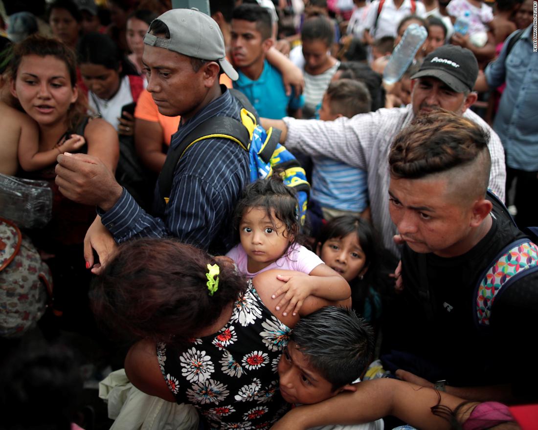 Children of migrants, part of the caravan, on Saturday wait with their parents to apply for asylum in Mexico at a checkpoint in Ciudad Hidalgo, Mexico.