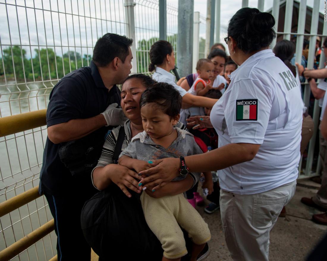 A Honduran migrant mother and her son walk on the bridge after crossing the border between Guatemala and Mexico on Saturday.