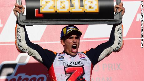 Marc Marquez celebrates on the podium after winning the Japanese MotoGP at Motegi to clinch his third straight world title for Repsol Honda and fifth overall.