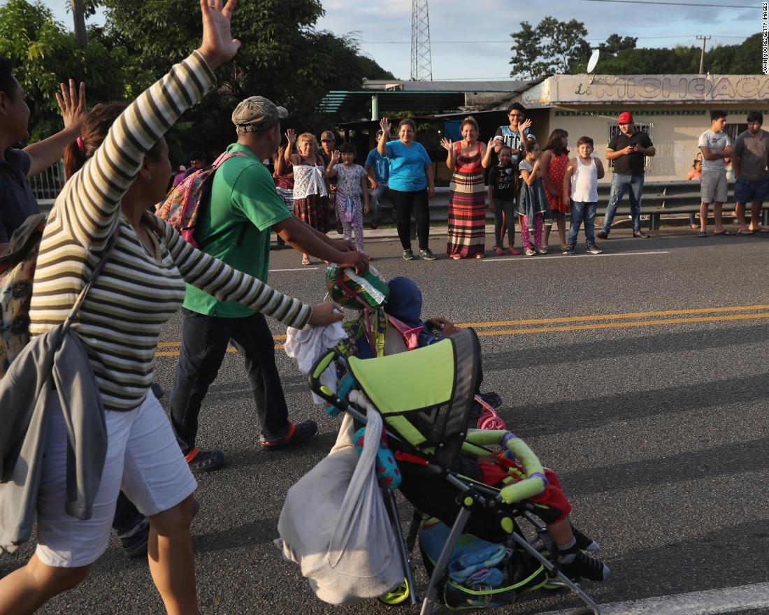 Local residents cheer as a migrant caravan walks into the interior of Mexico after crossing the Guatemalan border.