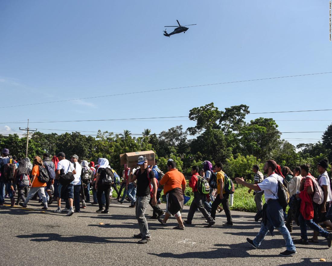 A Mexican Federal Police helicopter flies over migrants heading in a caravan to the United States, on the road linking Ciudad Hidalgo and Tapachula in Mexico.