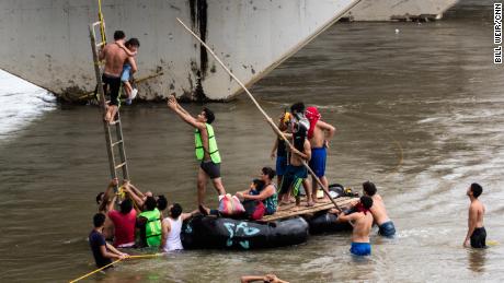 Helpers reach out to Candy as she nears the raft.