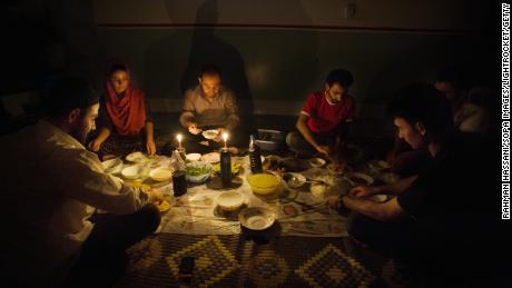 A family in Iraq sits by candlelight due to blackouts caused by the country's infrastructure problems.