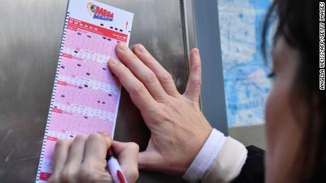 A woman fills out a Mega Millions lottery ticket on October 19, 2018 in New York City. 