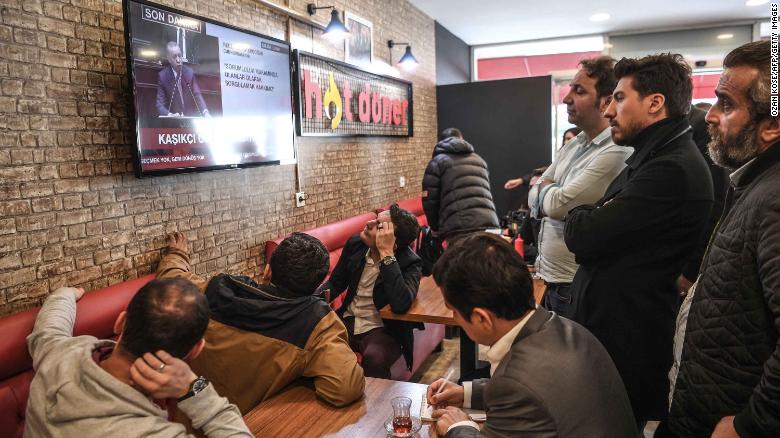 People gather around a TV at an Istanbul cafe to watch Erdogan&#39;s speech.