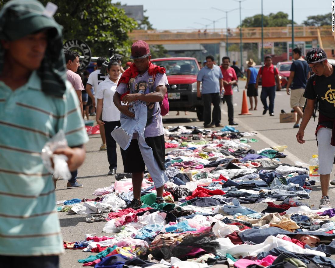 Migrants select clothes that have been placed along the road by Mexican citizens. 