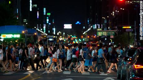 Pedestrians cross a road in the Gangnam district of Seoul. South Korea has some of the longest working hours in the world. 