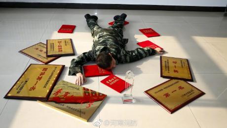 A Henan Fire Department employee lies among the awards he has won for his work, the government body&#39;s response to the &quot;Flaunt your wealth&quot; campaign on Chinese social media.