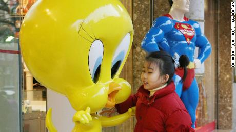 A young Chinese girl plays on a 'Tweety Bird' statue outside a newly opened Warner Brothers store on the Nanjing Road shopping street in Shanghai, 09 February 2006. 