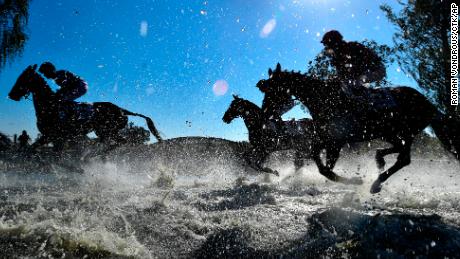 Horses and jockeys compete during the Steeplechase cross country in Pardubice, Czech Republic.