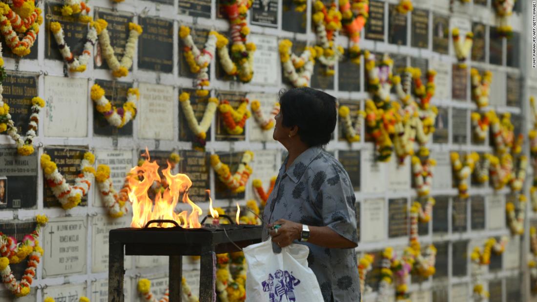 A woman prays near a plaque commemorating relatives on All Souls Day at a cemetery in Mumbai, India, on November 2, 2017. All Souls Day is observed in remembrance of friends and loved ones who passed away.