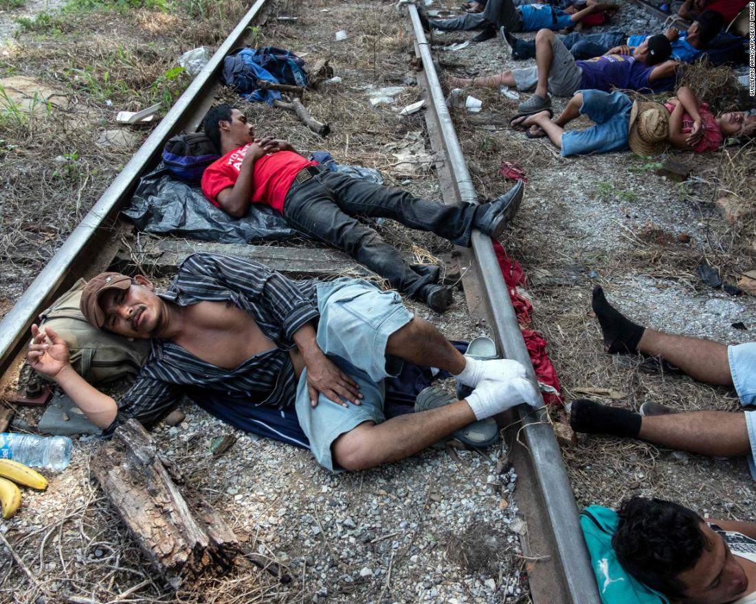 Migrants heading in caravan to the United States rest on the train tracks in Arriaga, Mexico.