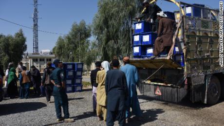 Afghan election employees unload ballot boxes from a truck at a polling center Friday ahead of Saturday's legislative polls in Kandahar province.