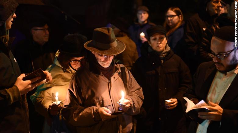 People hold candles outside the Tree of Life Synagogue after a shooting there left 11 people dead in the Squirrel Hill neighborhood of Pittsburgh on October 27, 2018.