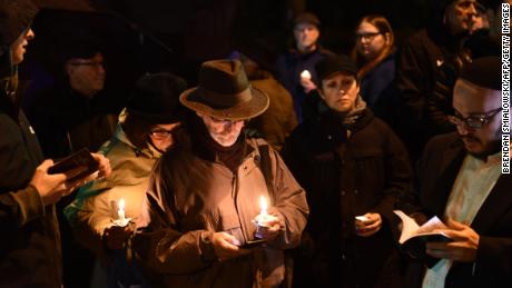 People hold candles outside the Tree of Life Synagogue after a shooting there left 11 people dead in the Squirrel Hill neighborhood of Pittsburgh on October 27, 2018.