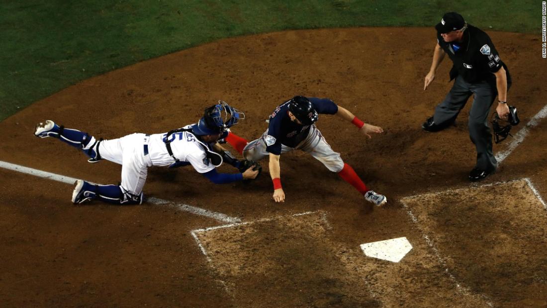 Ian Kinsler of the Red Sox is tagged out at home plate by Austin Barnes of the Dodgers on a throw from Cody Bellinger during the 10th inning of Game 3. The  Dodgers won in the 18th inning of a game that set the record as the longest in World Series history.