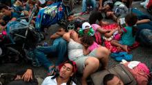 Members of a US-bound migrant caravan rest on a road between the Mexican states of Chiapas and Oaxaca after federal police briefly blocked them outside the town of Arriaga, Saturday, Oct. 27, 2018. Hundreds of Mexican federal officers carrying plastic shields had blocked the caravan from advancing toward the United States, after several thousand of the migrants turned down the chance to apply for refugee status and obtain a Mexican offer of benefits. (AP Photo/Rodrigo Abd)