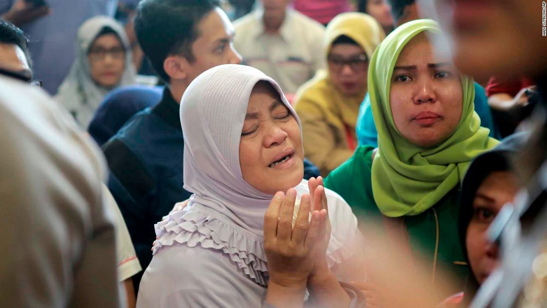 A woman in Pangkal Pinang prays as she and others wait for news on October 29.