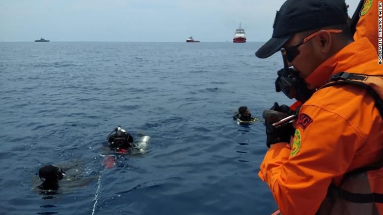 Divers work near the site where an Indonesian passenger plane crashed on Monday, October 29. 