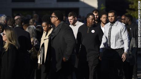 Members of the Pittsburgh Steelers stand with others Tuesday morning outside the Rodef Shalom Temple, where the services for the Rosenthal brothers were to be held. 