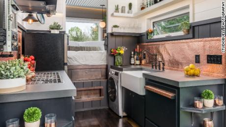 The full-sized kitchen, with king sized bed just beyond, in the Escher model tiny home from New Frontier Tiny Homes.