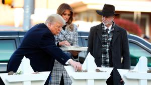 President Donald Trump and first lady Melania Trump put down stones from the White House at a memorial outside for those killed at the Pittsburgh's Tree of Life Synagogue in Pittsburgh, Tuesday, October 30, 2018, as Tree of Life Rabbi Jeffrey Myers watches. 