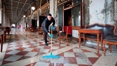 A man brushes away floodwater outside the historic Caffe Florian in St. Mark's Square on Tuesday.