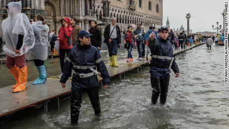 Local police start to clear people from St. Mark's Square on Monday because of the flooding.